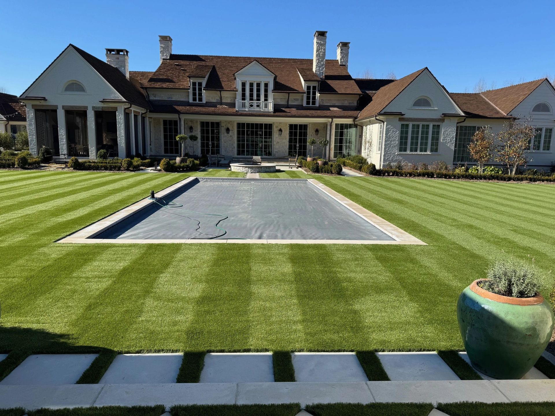 Designed backyard with a pool surrounded by lush, layered landscaping